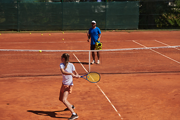 Image showing A professional tennis player and her coach training on a sunny day at the tennis court. Training and preparation of a professional tennis player