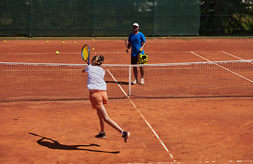 Image showing A professional tennis player and her coach training on a sunny day at the tennis court. Training and preparation of a professional tennis player