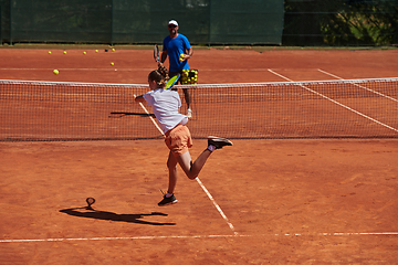 Image showing A professional tennis player and her coach training on a sunny day at the tennis court. Training and preparation of a professional tennis player