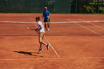 Image showing A professional tennis player and her coach training on a sunny day at the tennis court. Training and preparation of a professional tennis player