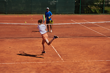 Image showing A professional tennis player and her coach training on a sunny day at the tennis court. Training and preparation of a professional tennis player