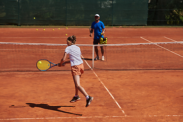 Image showing A professional tennis player and her coach training on a sunny day at the tennis court. Training and preparation of a professional tennis player