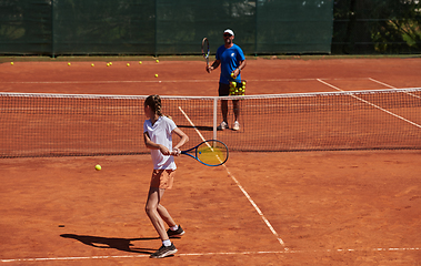 Image showing A professional tennis player and her coach training on a sunny day at the tennis court. Training and preparation of a professional tennis player