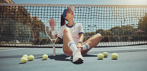 Image showing Tennis, athlete and woman ready for a tennis match while sitting on the court with tennis balls. Fitness, active and young girl holding a tennis racket and ball ready for training or playing game