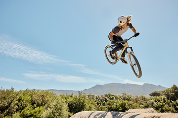 Image showing Mountain bike, high jump and athlete doing a trick in nature for a competition or training. Bicycle, fitness and cyclist doing a crazy stunt in the air with adrenaline for a fun sports championship.