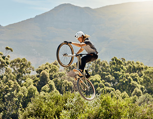 Image showing Sport, action and biker doing jump in air with mountain bike for extreme sports, adrenaline and hobby. Fitness, adventure and woman on bike doing trick shot, jumping and stunt on bicycle in nature