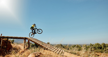 Image showing Sports, mountain bike and ramp jump in nature, cycling .and outdoors stunt performance. Fitness, workout and exercise of bmx athlete and racer on bicycle training for competition, race or contest.