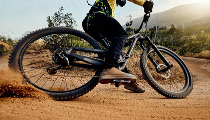 Image showing Sports, action and biker dirt racing on mountain bike enjoying riding, cycling and moving with speed. Extreme sports, mountain biking and athlete drifting on dirt road for fitness, adrenaline and fun