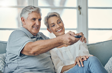 Image showing Senior couple, smile and hug watching TV for entertainment on living room sofa with remote at home. Happy elderly man and woman relaxing on couch streaming movies, shows or media at the house