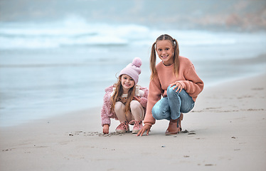 Image showing Sisters, beach and happy with smile, on sand and have fun together being playful, joy and cheerful for holidays. Portrait, siblings or girls at ocean for bonding, loving or seaside vacation for break