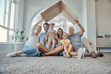 Image showing Big family, children and insurance with a mother, father and grandparents sitting under cardboard in the living room in home together. Kids, love and cover with parents and senior people in house