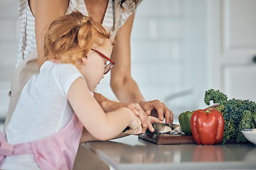 Image showing Mother teaching, child cutting vegetable and learning skill in home kitchen together on counter. Girl knife focus, cooking education with mom teacher and cut vegetables for dinner food in house