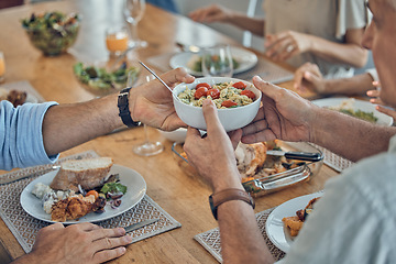 Image showing Hands, food and family with a group of people gathered around a dining room table for a meal or feast at home. Salad, buffet and celebration with relatives eating lunch or supper together in a house