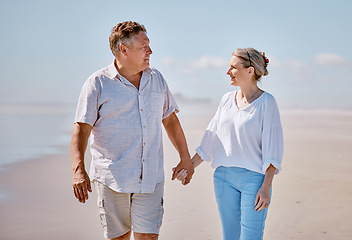 Image showing Beach, love and senior couple holding hands while walking for health, exercise and wellness. Happy, romance and elderly man and woman on romantic walk together in nature by ocean or sea in Australia.