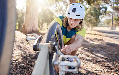 Image showing Man, bicycle and repair with wheel maintenance for fitness exercise or training for race or competition. Biker, athlete and fix bike, gear and equipment for journey, sports and tire fixing outdoor