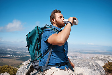 Image showing Hiking, fitness and view with a man drinking water while taking a break from walking in nature for exercise. Mountain, health and summer with a male hiker having a drink from a bottle while exploring