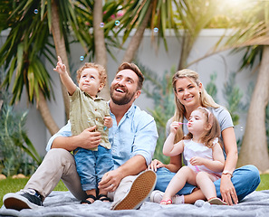 Image showing Family garden, bubbles and children with parents together with a smile and quality time. Happy kids, mother and father feeling love and care with a baby looking at bubbles ready for a summer picnic