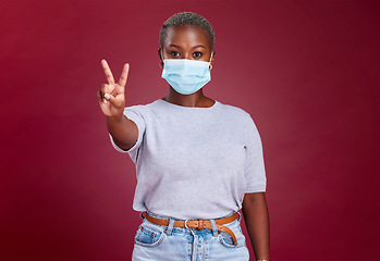 Image showing Black woman, covid face mask or peace sign on red background in studio healthcare vote, wellness opinion or compliance solidarity. Portrait, covid 19 or cool hand gesture on advertising mock up space