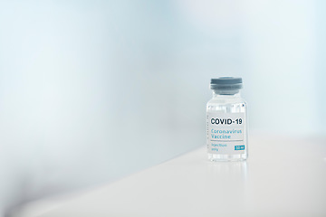 Image showing Covid, vaccine and medication with a bottle of a liquid on a table in the hospital as a cure or treatment. Healthcare, pharmacy and medicine in a corona research lab for pharmaceutical development