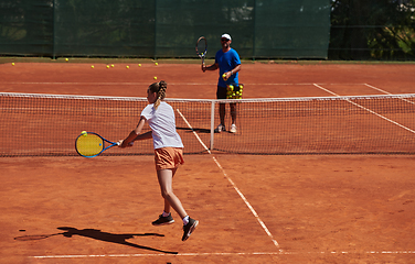 Image showing A professional tennis player and her coach training on a sunny day at the tennis court. Training and preparation of a professional tennis player