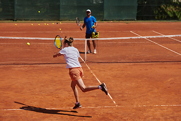 Image showing A professional tennis player and her coach training on a sunny day at the tennis court. Training and preparation of a professional tennis player