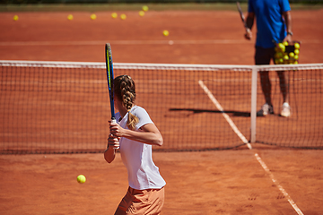 Image showing A professional tennis player and her coach training on a sunny day at the tennis court. Training and preparation of a professional tennis player