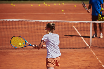 Image showing A professional tennis player and her coach training on a sunny day at the tennis court. Training and preparation of a professional tennis player