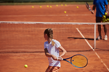 Image showing A professional tennis player and her coach training on a sunny day at the tennis court. Training and preparation of a professional tennis player