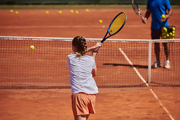 Image showing A professional tennis player and her coach training on a sunny day at the tennis court. Training and preparation of a professional tennis player