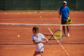 Image showing A professional tennis player and her coach training on a sunny day at the tennis court. Training and preparation of a professional tennis player