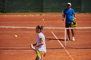 Image showing A professional tennis player and her coach training on a sunny day at the tennis court. Training and preparation of a professional tennis player