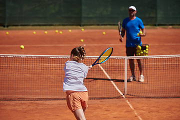 Image showing A professional tennis player and her coach training on a sunny day at the tennis court. Training and preparation of a professional tennis player