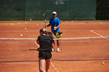 Image showing A professional tennis player and her coach training on a sunny day at the tennis court. Training and preparation of a professional tennis player