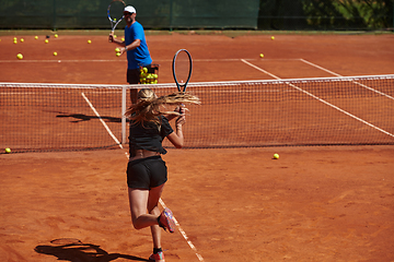 Image showing A professional tennis player and her coach training on a sunny day at the tennis court. Training and preparation of a professional tennis player