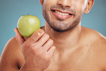 Image showing Man, hands and holding apple on blue background in studio for health, wellness or immune support. Zoom, smile and happy personal trainer with diet fruit for weight loss, wellness or food for workout