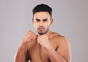 Image showing Fist, boxing and young man on studio background doing training for health, fitness and wellness with workout. Indian male, fight position and dedicated for match, motivation and energy for practice.