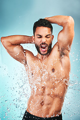 Image showing Muscular man, water splash and health for wellness, fitness and hygiene with blue studio background. Sing, athlete male and bodybuilder enjoy shower, wash clean or excited for body care after workout