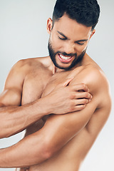 Image showing Beauty, body and injury with a man model holding his shoulder in pain in studio on a gray background. Fitness, health and anatomy with a young male suffering with muscle cramp, ache or inflammation