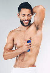 Image showing Spray, armpit and man with smile for deodorant against grey studio background. Skincare, smile and strong model with antiperspirant bottle for wellness, skincare and grooming while spraying underarm