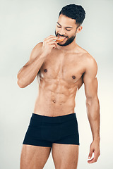 Image showing Health, fitness man and healthy diet while eating an orange for vitamin c, nutrition and wellness with a fit body, smile and underwear. Male athlete model with fruit for energy and self care benefits