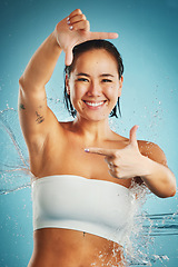 Image showing Shower, water and hands with a woman in studio on a blue background for hygiene or hydration. Frame, cleaning and bathroom with a female washing or cleansing with hand sign for hygienic body care