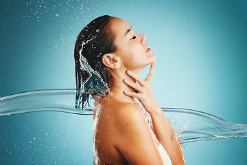 Image showing Splash, water and woman with care for body, cleaning and in shower against a blue mockup studio background. Spa, health and Asian model with natural liquid to clean skin for wellness and beauty