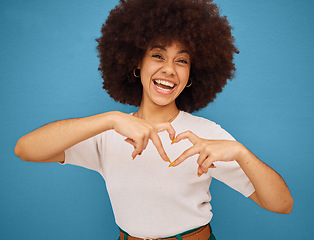 Image showing Love, heart and woman with a smile for fashion, marketing and advertising against a blue mockup studio background. Excited, happy and portrait of a creative and African girl with emoji hands for care