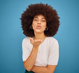 Image showing Love, happy and woman blowing kiss for fashion, comic and young lifestyle against blue mockup studio background. Smile, flirty and portrait of African girl model with affection, comedy and happiness