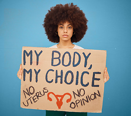 Image showing Protest, human rights and woman with a poster for abortion, body freedom and justice against a blue studio background. Choice, equality and portrait of an African girl with a board for a riot