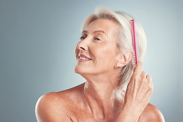 Image showing Hair, beauty and senior woman brushing hair, grooming and in studio for wellness, routine and self care on grey background. Grey hair, elderly model and comb by lady styling, relax and hygiene care