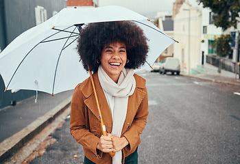 Image showing Rain, umbrella and city with a walking black woman in the street during a cold or wet winter day. Water, insurance and cover with a young afro female outdoor for a walk in an urban town road