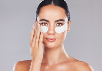 Image showing Skincare, face and woman with eye patches on a gray studio background. Health, beauty or female model from Spain with facial product, cosmetics pads or collagen eye mask for hydration or anti aging