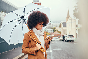 Image showing Woman, umbrella and smartphone in city for social media content creation in autumn. Young influencer, digital networking or student read online web communication on mobile phone in urban town