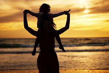 Image showing Silhouette, sunset and mother with a child on the beach while on summer vacation or adventure. Love, care and shadow of family in nature by the ocean or sea on holiday journey together in the evening